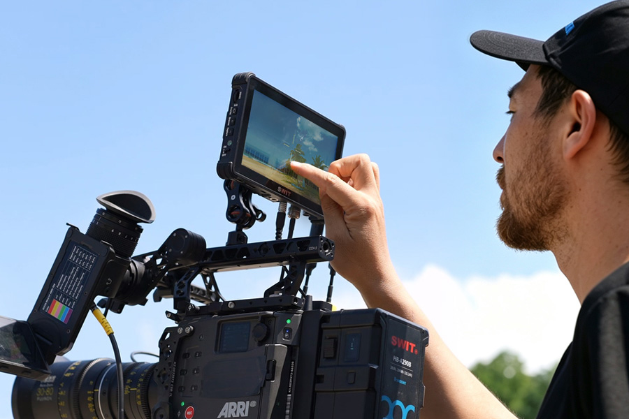 Camera operator using a K7 monitor on an ARRI camera outdoors